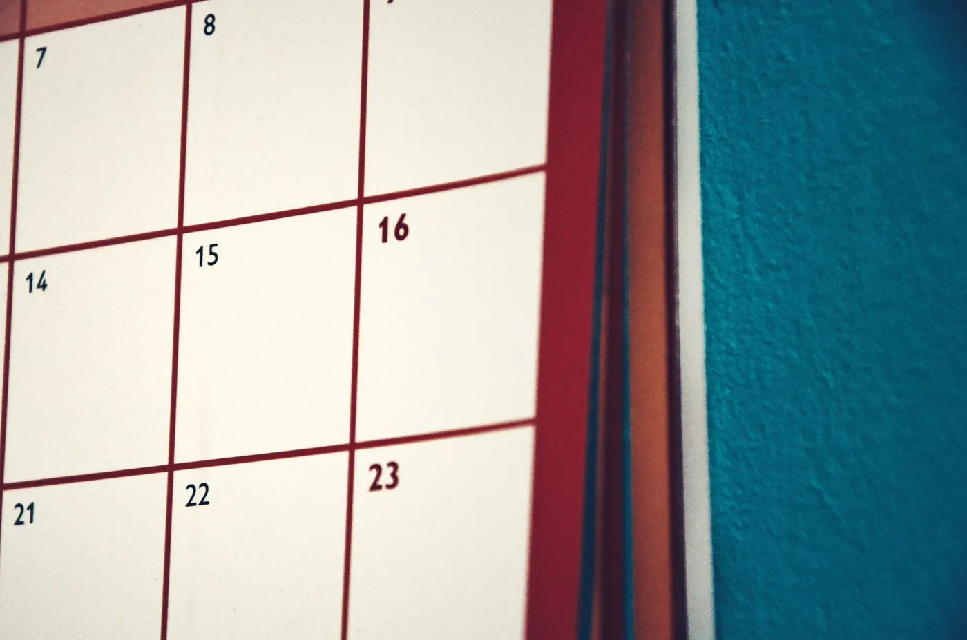 A wall calendar in close focus, its numbered squares 7 through 23 empty and unmarked