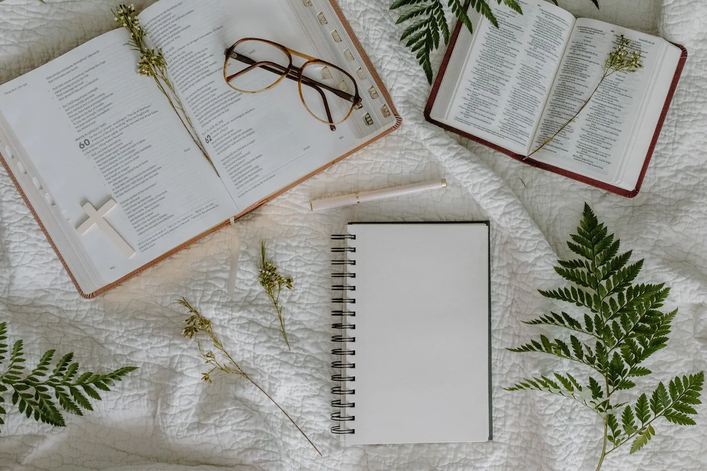 An open Bible and a notebook on a desk