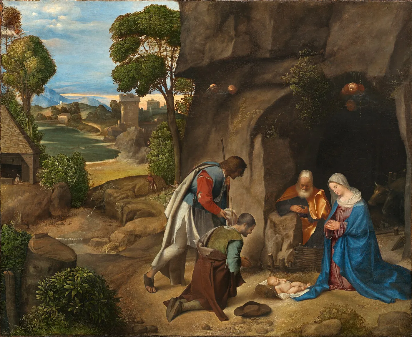 Giorgione's Adoration of the Shepherds: Mary and Joseph kneeling beside the newborn Jesus at the mouth of a rocky cave, with two shepherds bowing before Him and a valley and town in the distance
